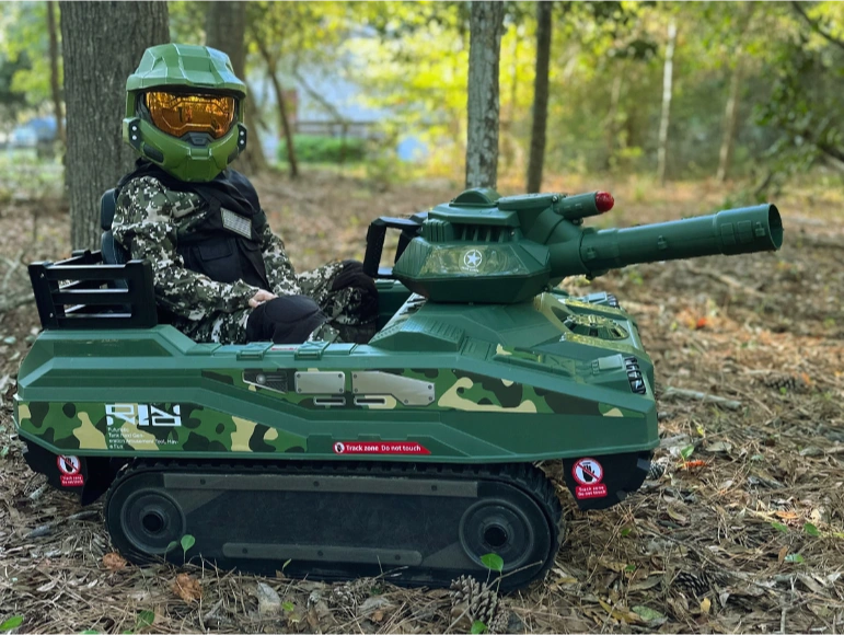 Pic of a Kid wearing a Camou cloth and helmet sitting on the M51 Shepard Tank by Tough Trucks for Kids