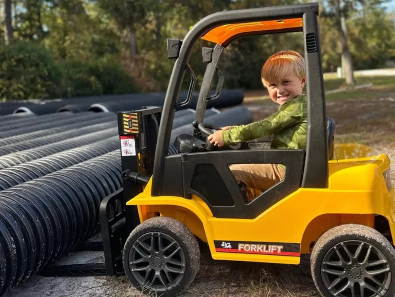 Kid smiling looking at the camera while sitting on the Forklift 9000 by Tough Trucks For Kids