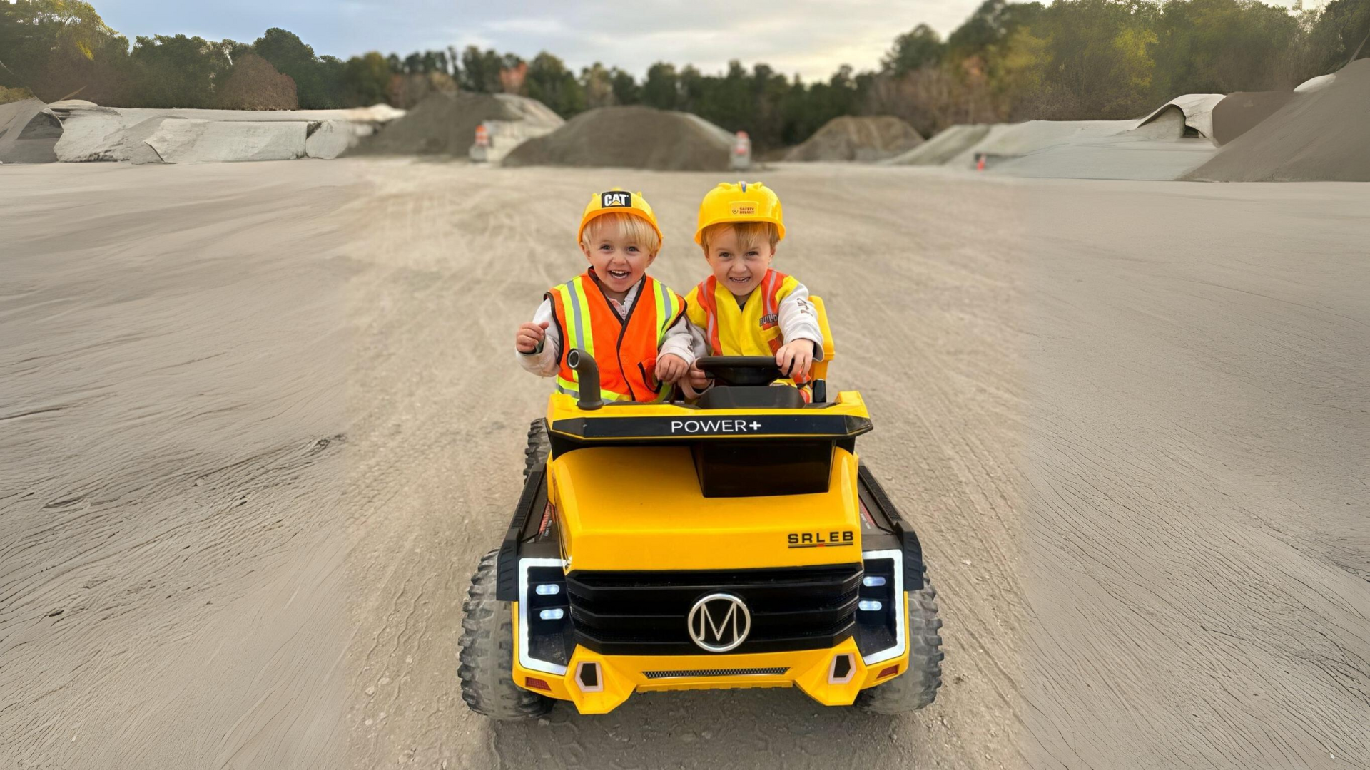 children playing with Power Wheels trucks in a park